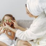 A mother and daughter enjoy a relaxing spa day at home with cucumbers and laughter.